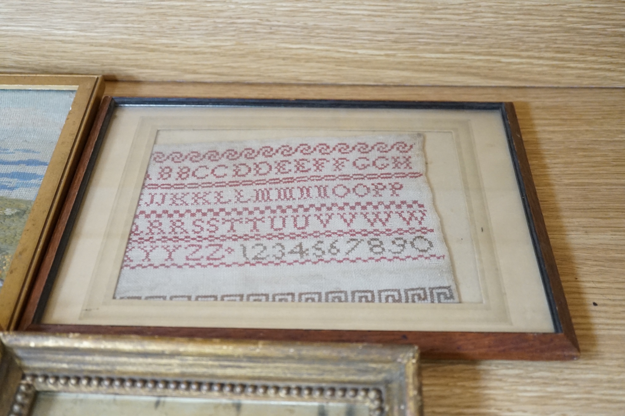 From the Studio of Fred Cuming. Six needlework embroideries including an alphabet sampler, Study of oak leaves, and 19th century landscapes, largest 23 x 29. Condition - varies, poor to fair
